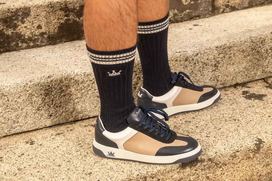 Navy and beige Lambda golf sneakers on stone steps